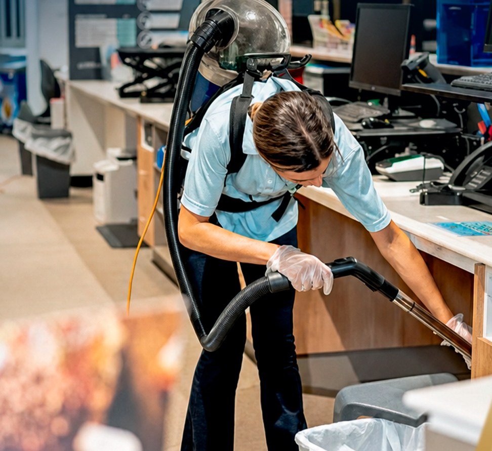 Gold Keys cleaner vacuuming an office reception with a backpack vacuum on the Gold Coast
