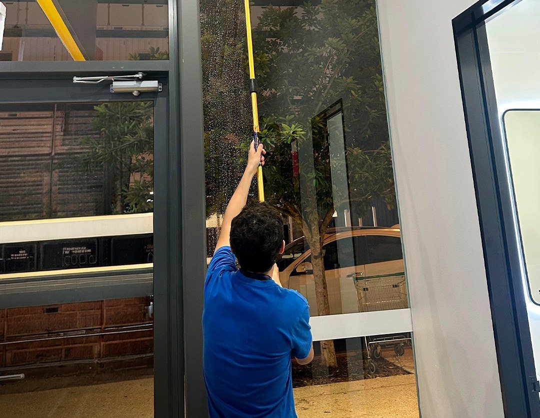 Gold Keys cleaner cleaning high glass in a commercial building lobby on the Gold Coast