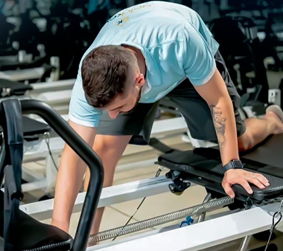 Gold Keys cleaner sanitising a pilates reformer at a Gold Coast fitness studio