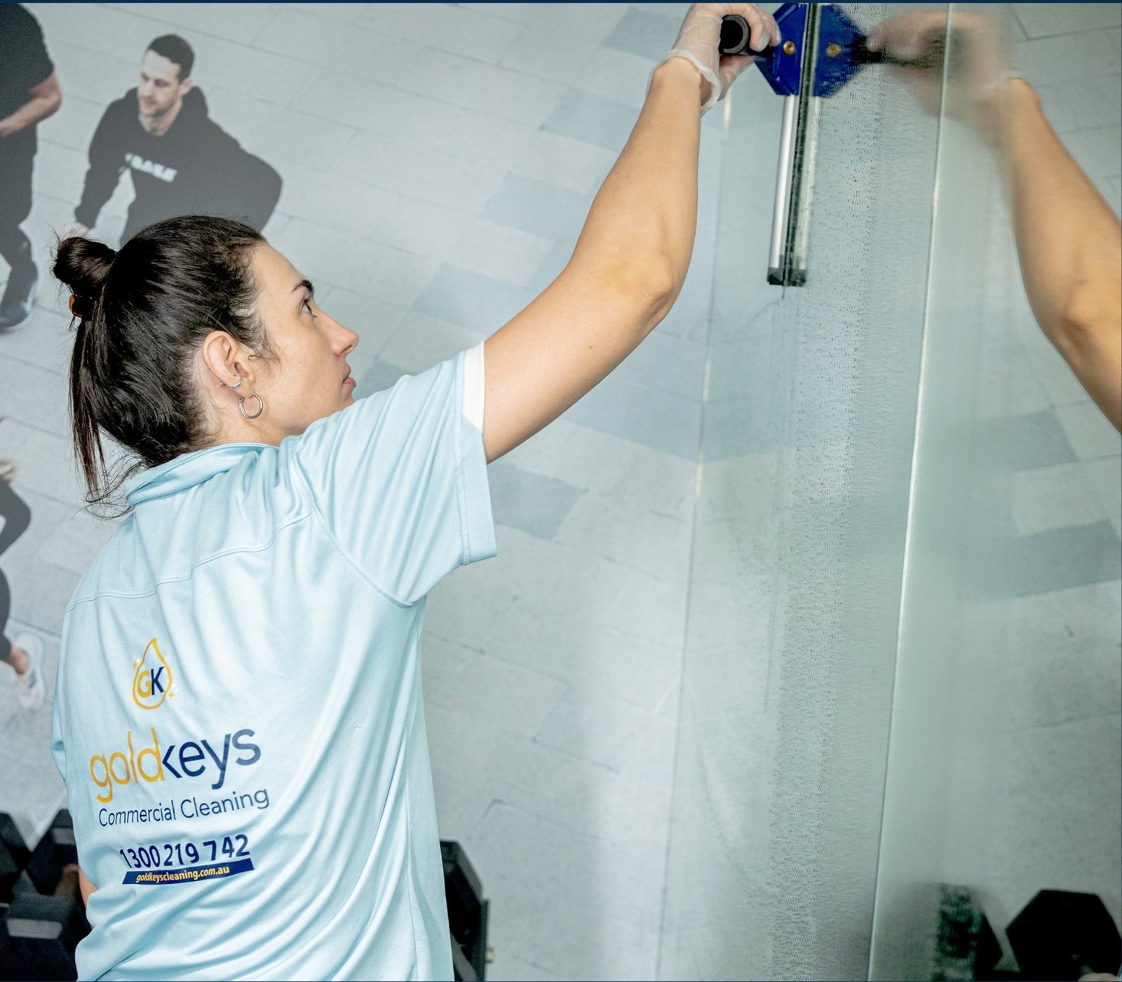 Gold Keys cleaner using a squeegee on glass during strata cleaning on the Gold Coast