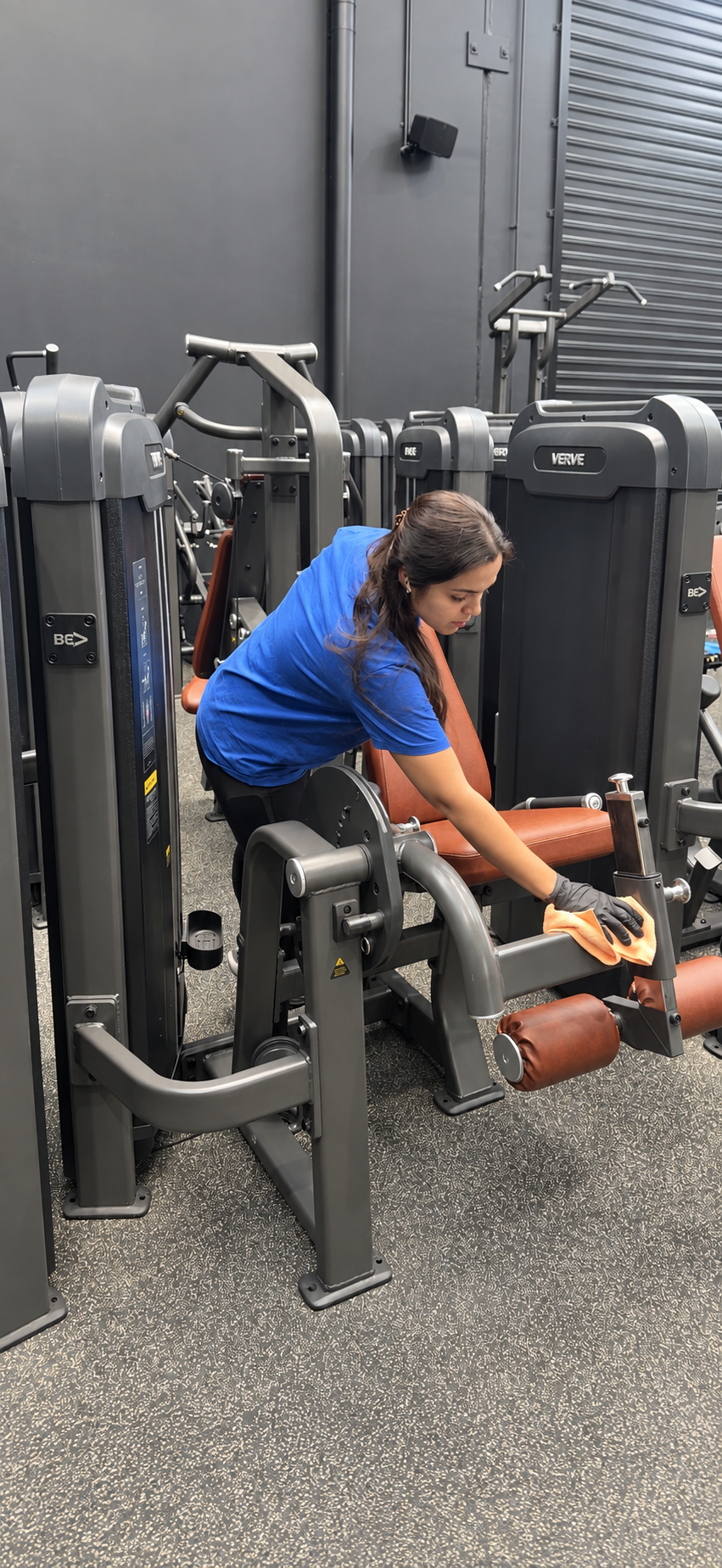 Gold Keys cleaner wiping a gym machine with a cloth