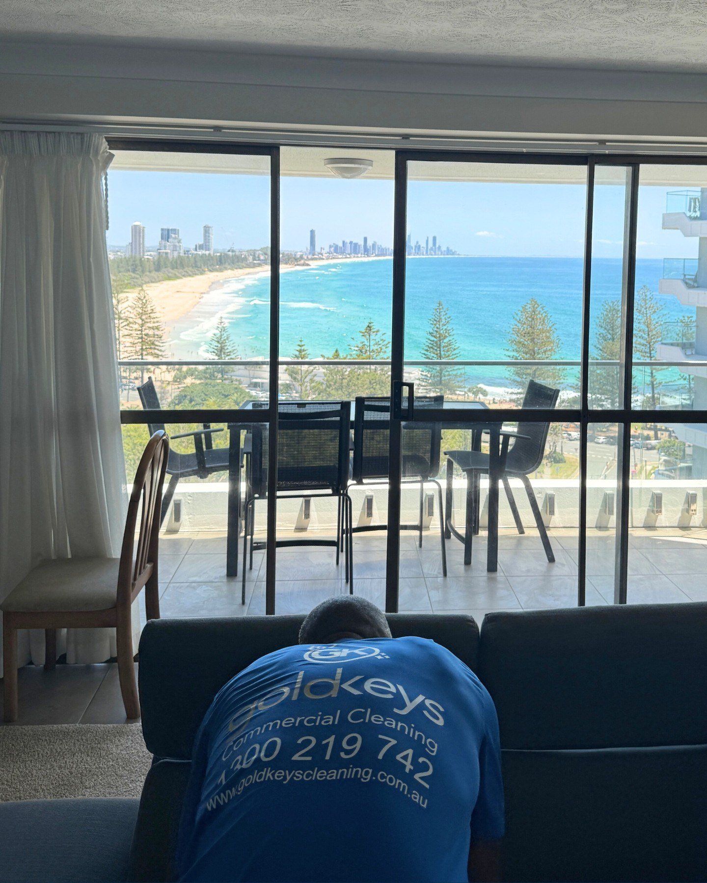 Gold Keys cleaner cleaning a sofa in a Gold Coast high-rise with ocean views