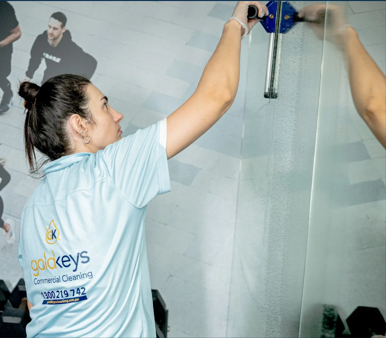 Gold Keys cleaner using a squeegee on glass during strata cleaning on the Gold Coast